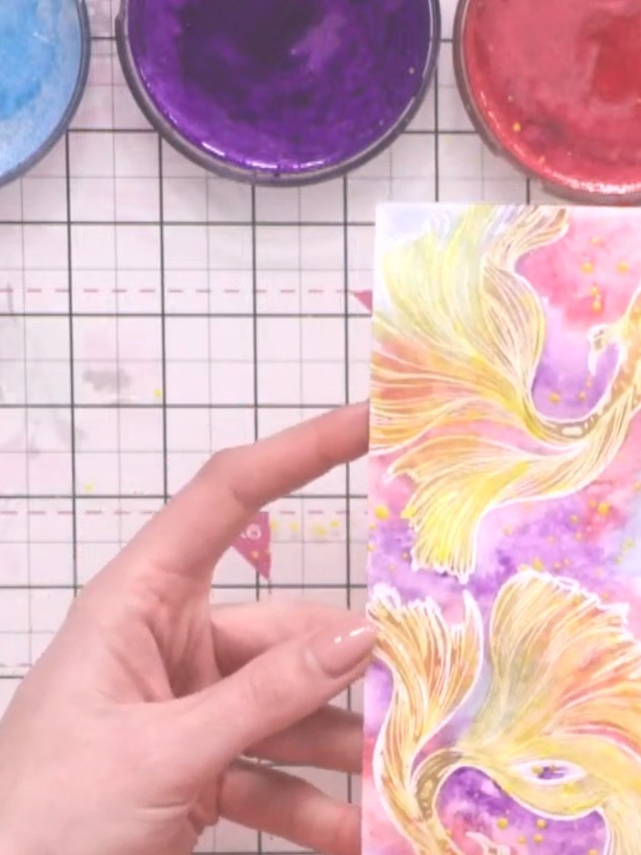 Step 14: Brush off any watercolour splatter spots that have landed on the white heat-embossed fish details, as they wil