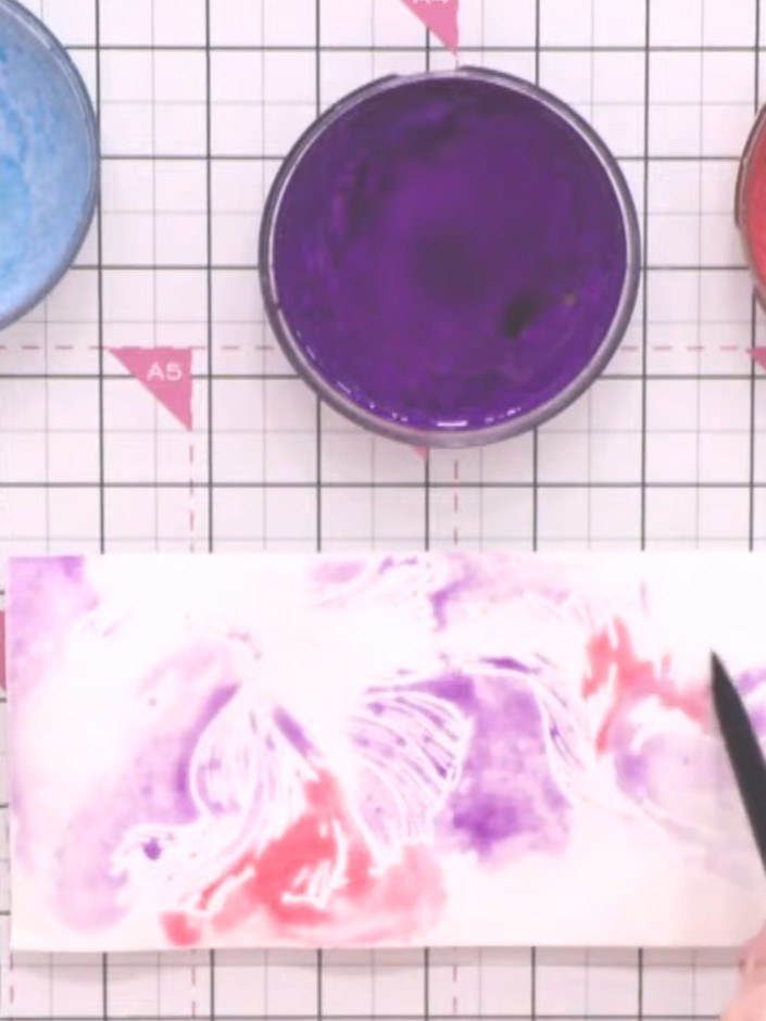 Step 9: Add red and pink colours to different areas of the card using a brush, keeping the colours somewhat separate r