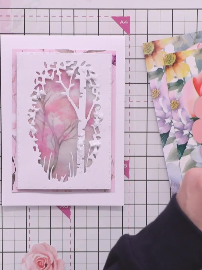 Step 5: Assemble the card by layering the decorated magnolia panel onto the pink mat and then onto the square card bas