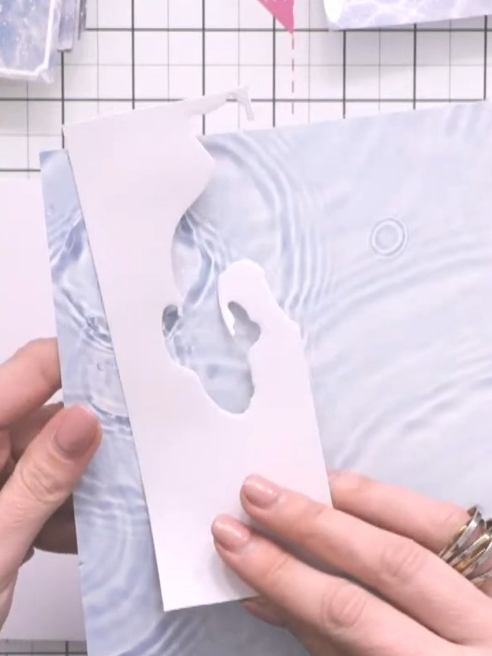Step 7: Cut a thin strip of the water-effect patterned paper and adhere it down the left side of the white panel as a 