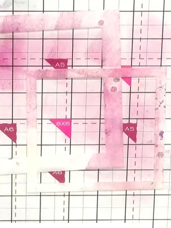 Step 1: Position a splatter stencil on your pink card base. Hold the stencil down gently to keep it in place whilst yo