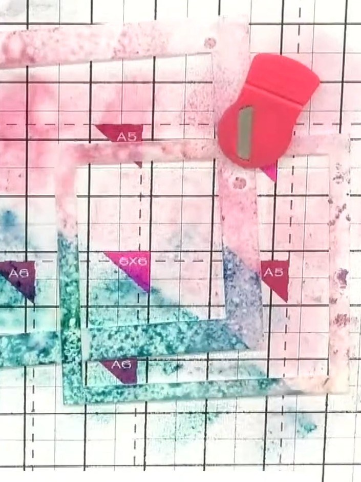 Step 4: Squirt water from a spray bottle all over the inked area to blend and diffuse the pink and turquoise colours t