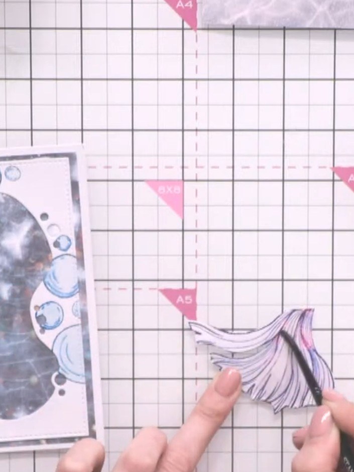 Step 9: Use a wet brush to drag and blend the colours on the fish tail, creating dimension and a watercolour effect.