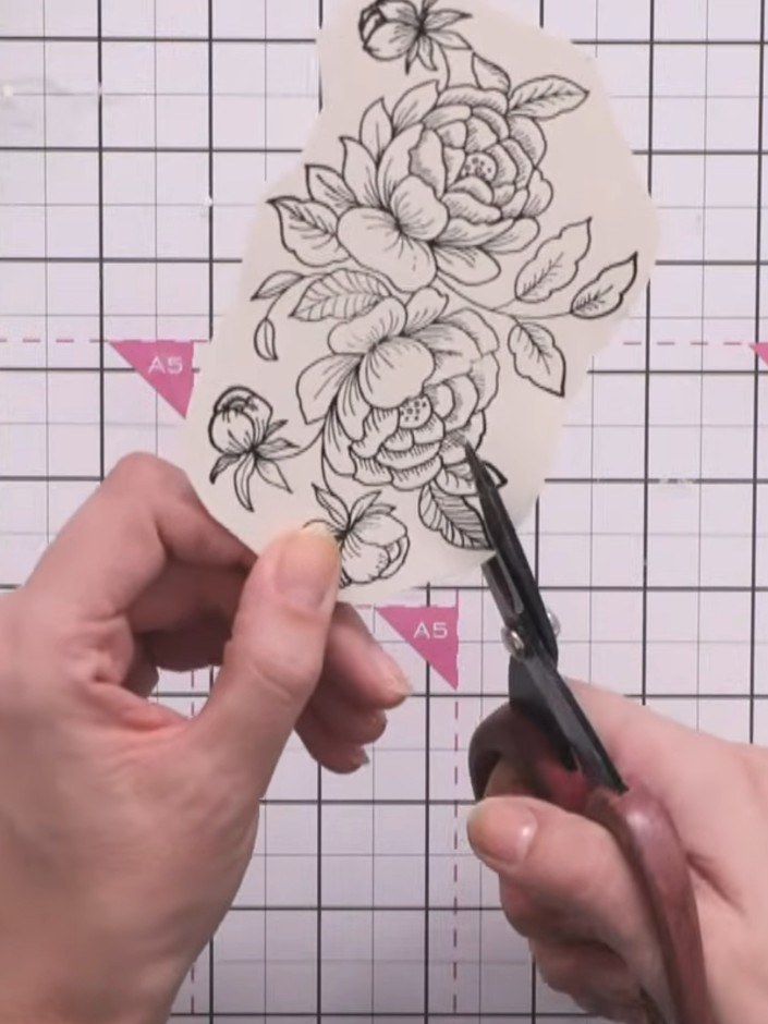 Step 5: Fussy cut around the floral stamp, leaving a small border. Hold your scissors at an angle so the paper does th