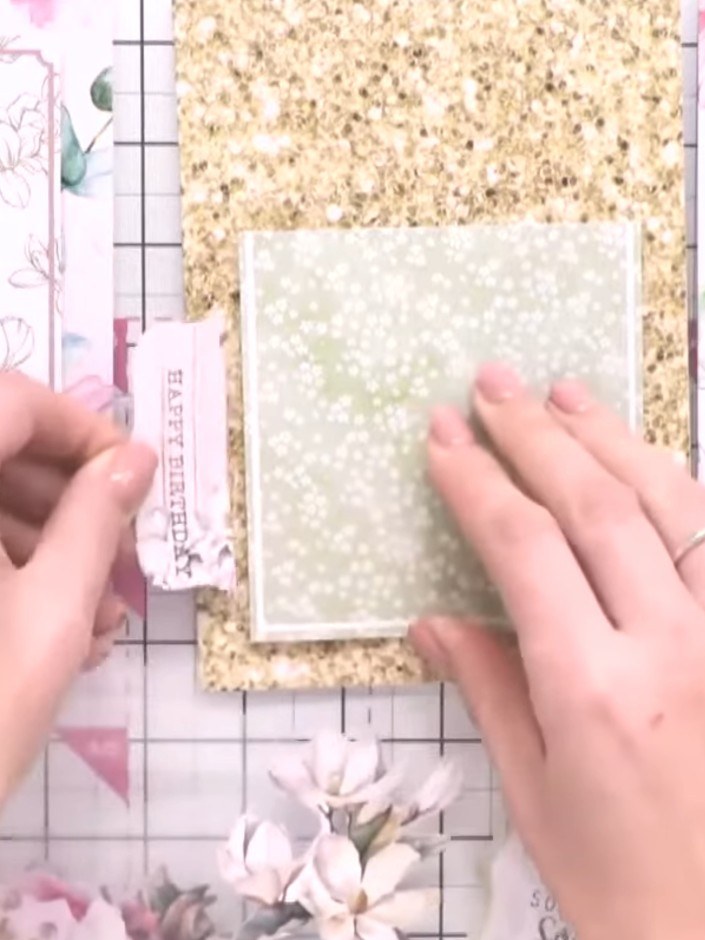 Step 6: Arrange the floral embellishments on your card, layering them over the topper panel and gold glitter card to c