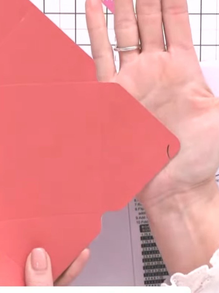 Step 8: Fold in the scored edges of the coral card. Push the side flaps inward to form the box shape, using the hook a