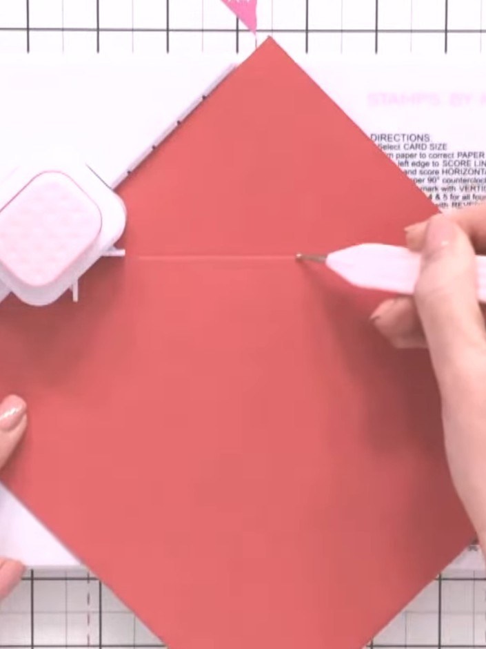 Step 3: Score at the marked line by inserting the coral paper into the scoring tool and dragging the tool across the p
