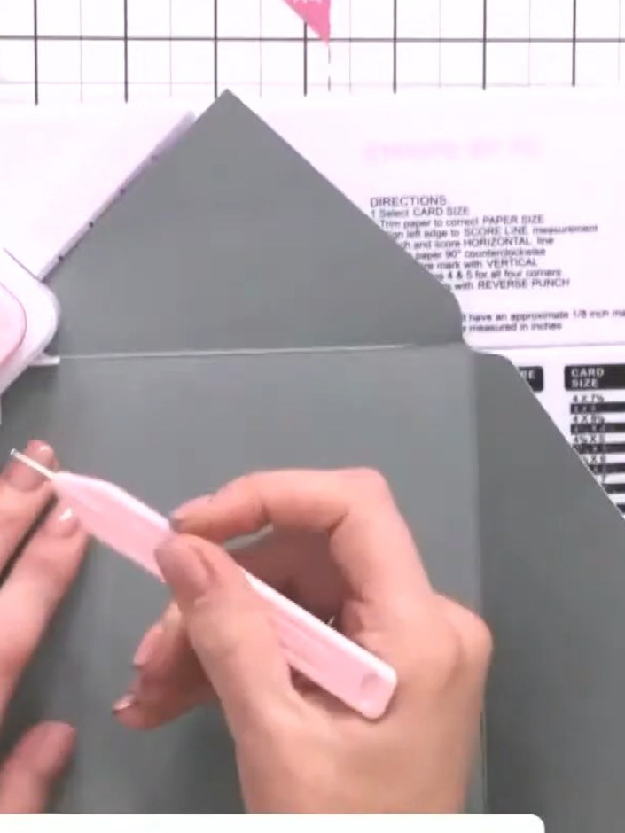 Step 8: Fold the grey envelope in half along the score line to complete the pointed flap envelope shape. Use the bone 