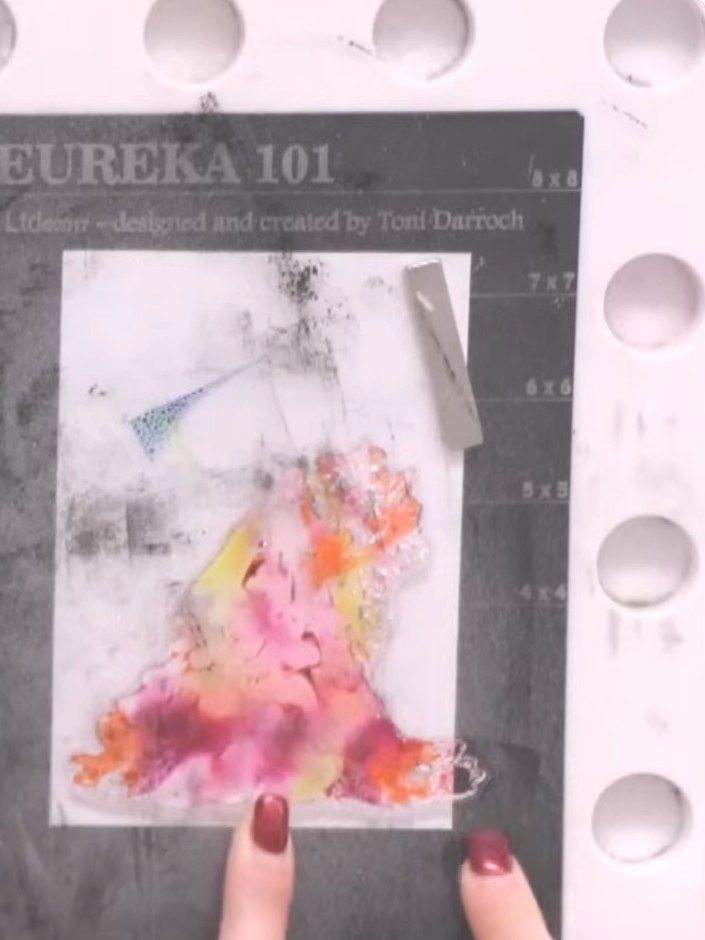 Step 4: Press the stamp firmly onto the white card stock, pushing down to transfer the blended pink, orange and yellow