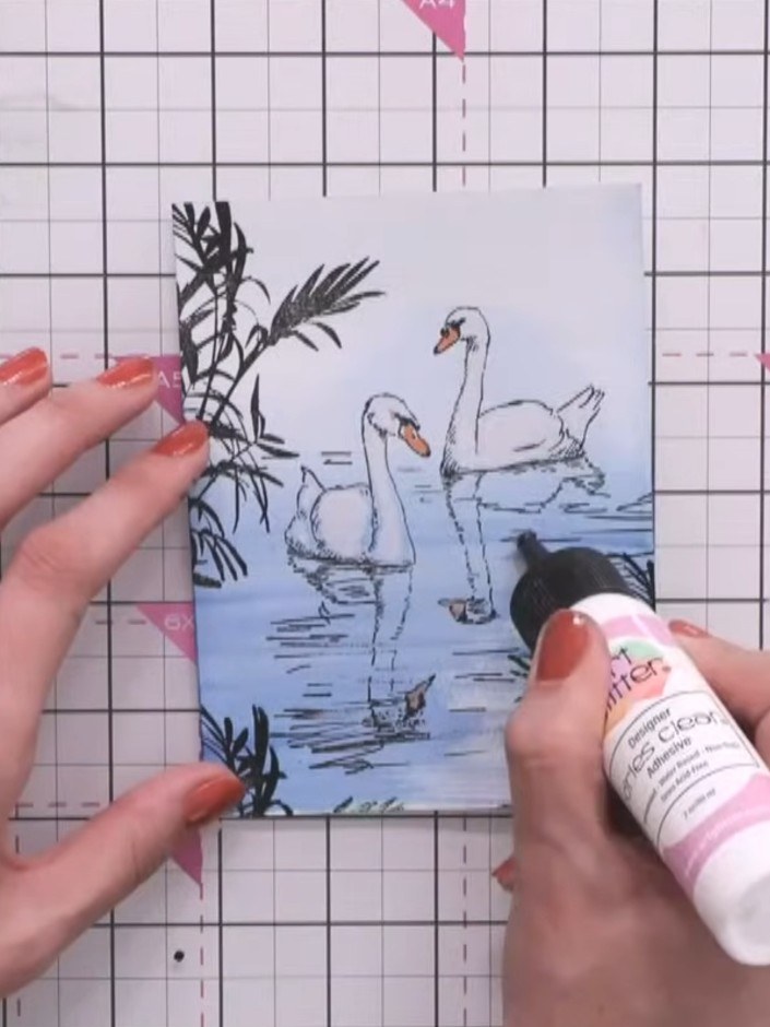 Step 10: Apply clear glue in random lines across the water area of the card. Sprinkle clear sparkles over the glue to c