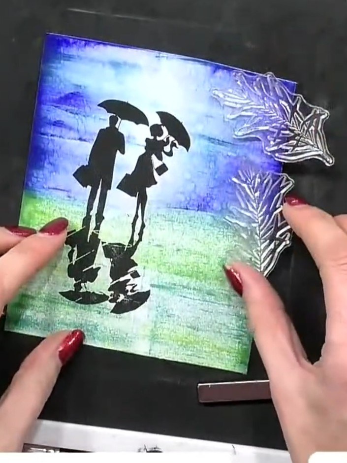Step 11: Stamp foliage and greenery around the figures using the leaf stamps. Position the foliage on both sides of the