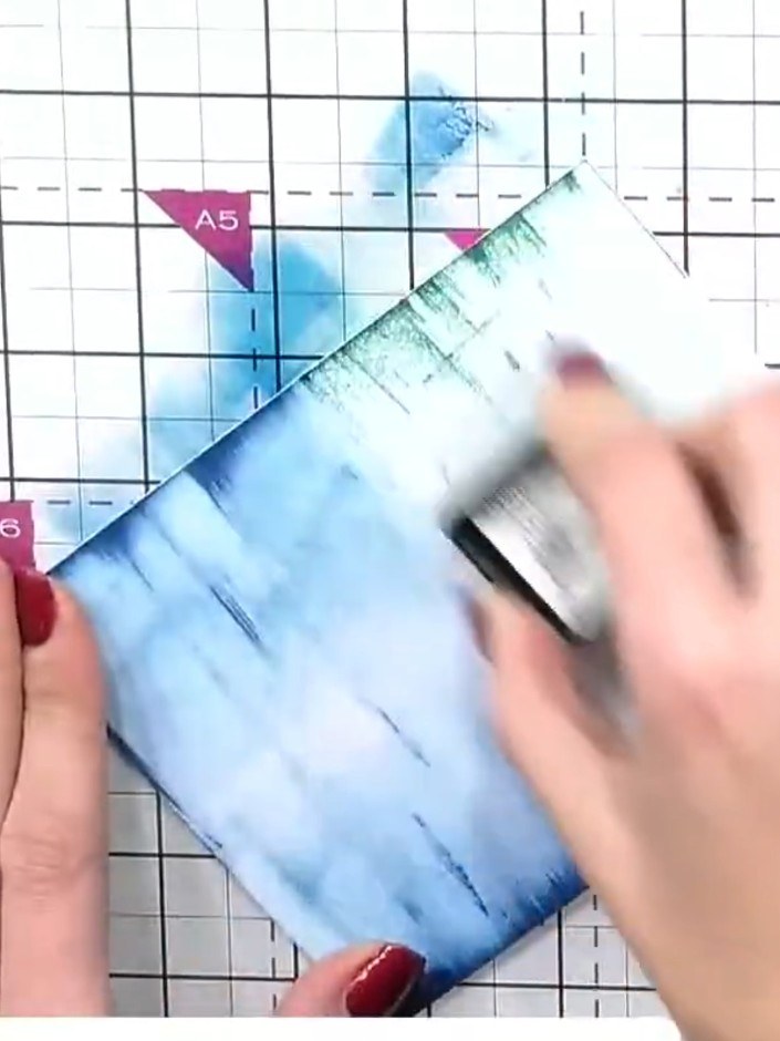 Step 4: Apply Evergreen Distress Ink to the bottom portion of the blue watercoloured card using the ink pad directly. 