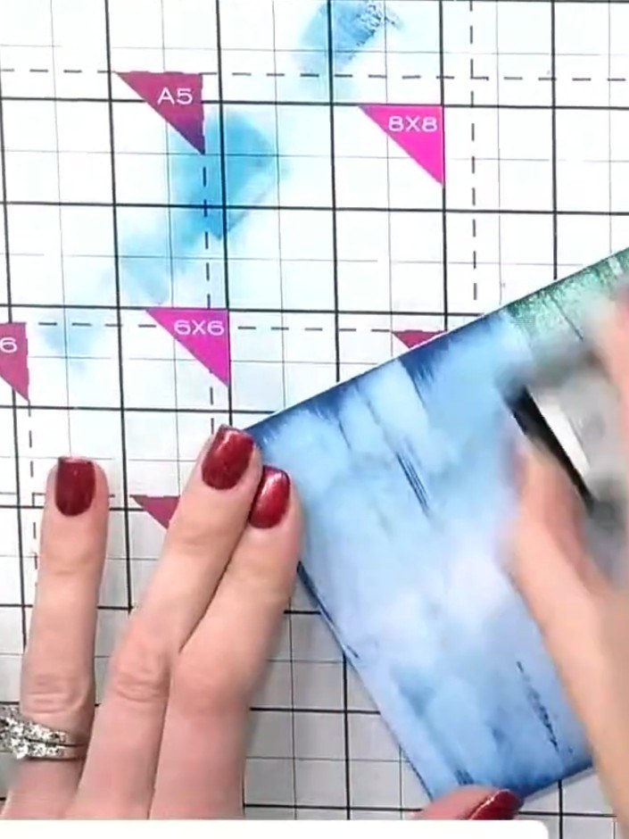 Step 5: Using an ink blending tool, swipe multiple shades of green ink across the watercolour background to create dep
