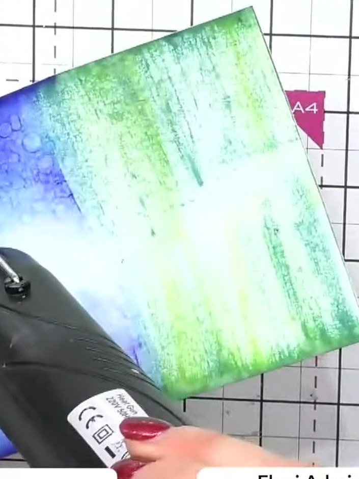 Step 8: Dry the card completely using a heat gun, holding it above the surface and moving it across the entire card un