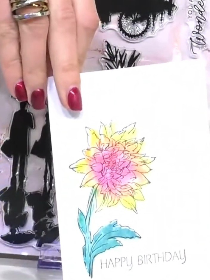 Step 4: Stamp the coloured flower image onto the wet lamination layer positioned over the black reflection stamp. This