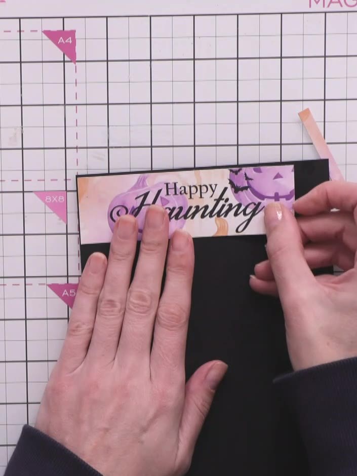 Step 10: Cut thin black borders from black card stock. Attach one strip to the top of the card and one to the bottom, c