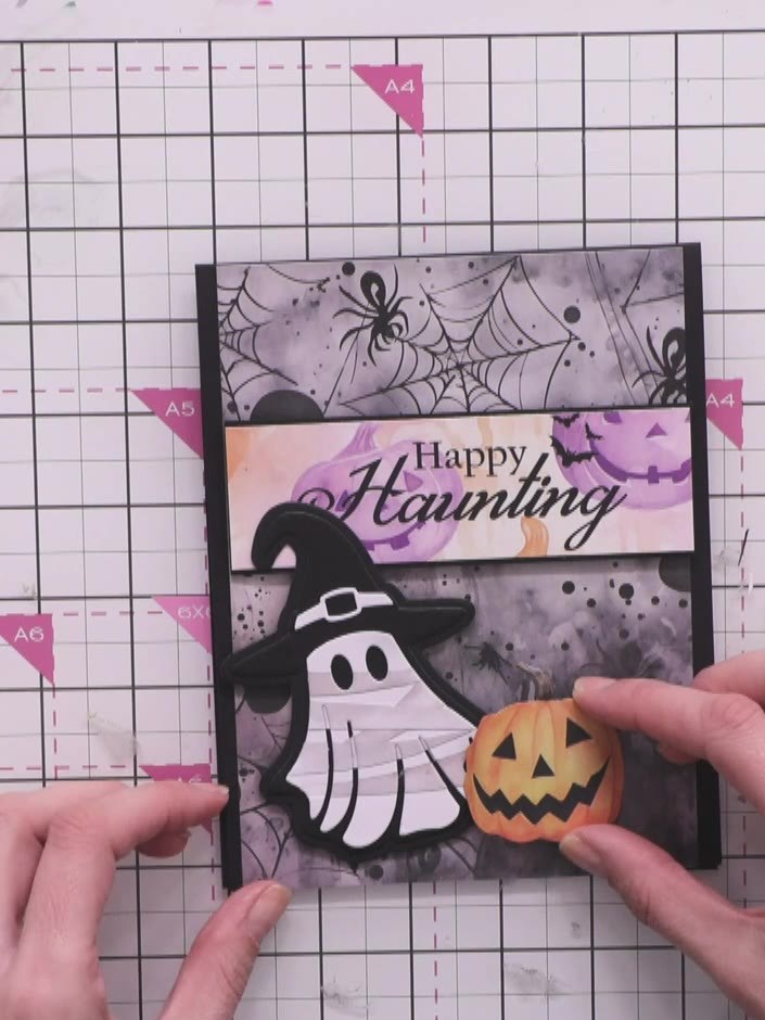 Step 14: Attach the orange pumpkin embellishment to the lower right of the ghost using foam pads for dimension.