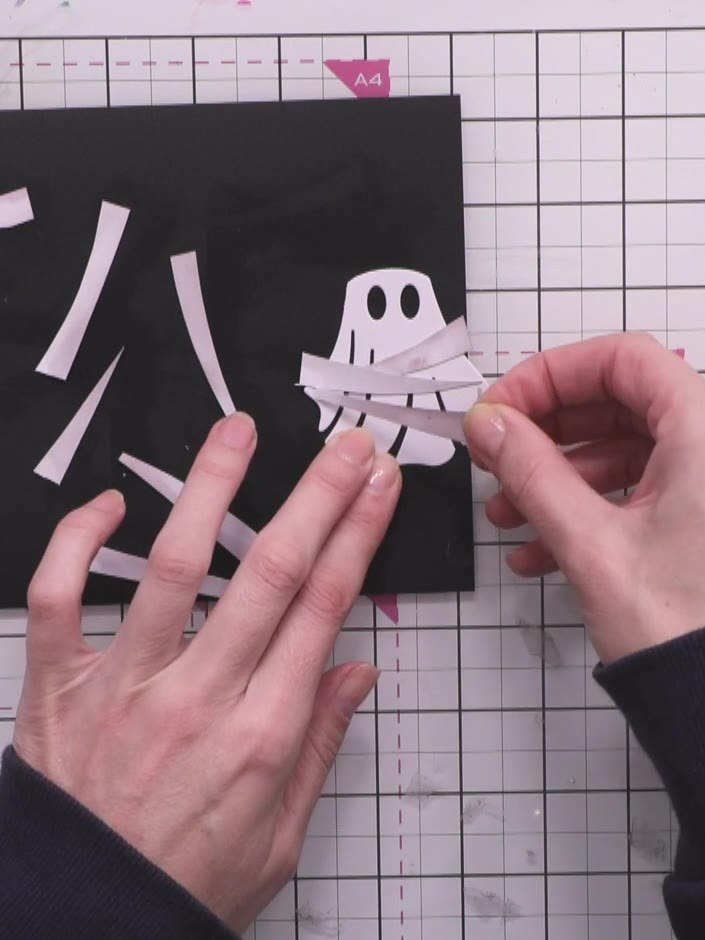 Step 8: Trim away any excess paper strips extending beyond the edges of the ghost shape using scissors or a craft knif