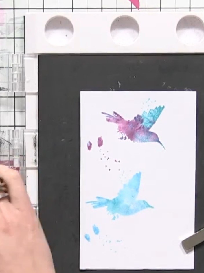 Step 9: Drück den Stempel fest auf den ersten Aquarellhintergrund. Ensure even pressure across the entire stam