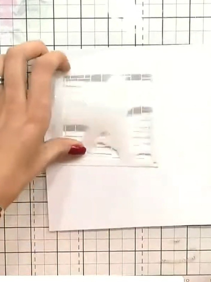 Step 2: Take stencil number one and position it carefully in the corner of your white card base, lining it up with the