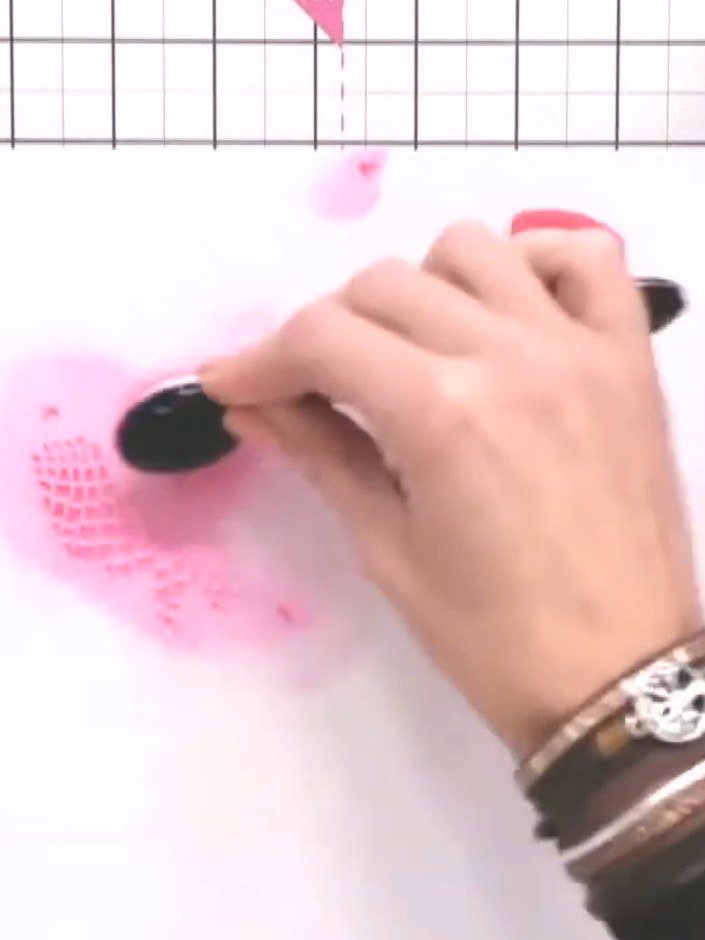 Step 3: Remove the first stencil and position the second stencil over your card. Using the blending tool, apply pink i