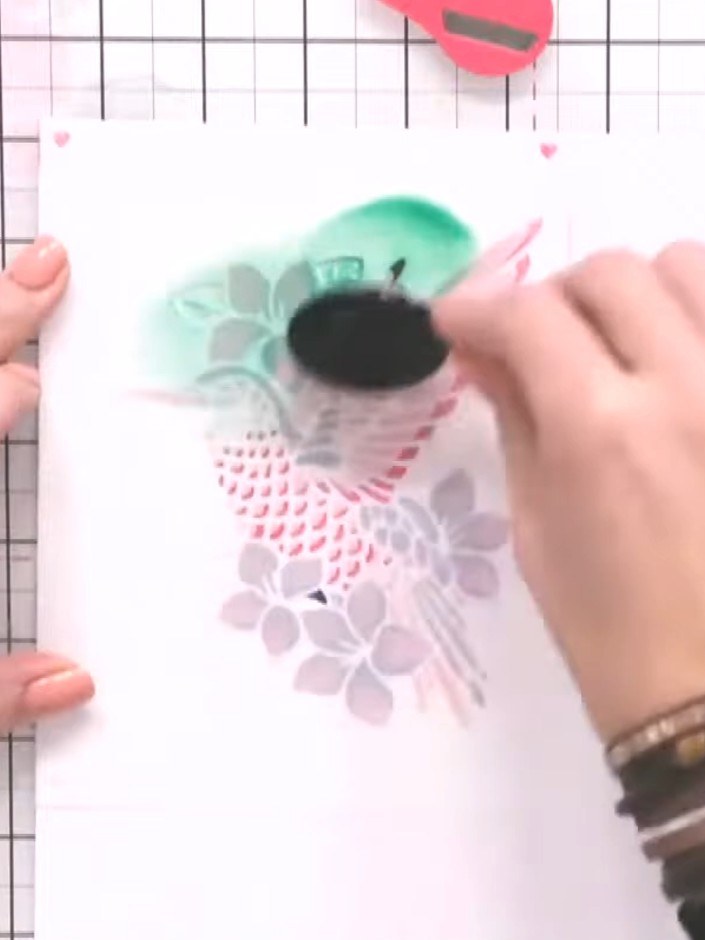 Step 8: Position the stencil back over your design and apply green sparkle paste or embellishment paste through the le