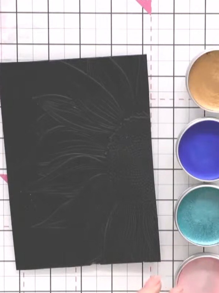 Step 3: Select several colours of gilding wax from your palette. Apply the wax randomly across the embossed sunflower 