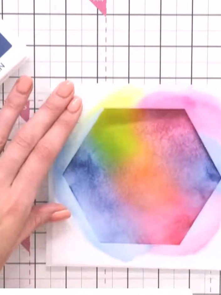 Step 5: Continue blending the rainbow colours by applying purple ink through the hexagon stencil onto the card. Use a 