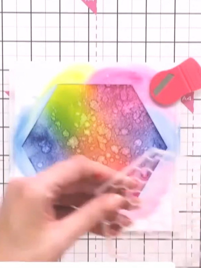 Step 8: Wet a piece of tissue with bleach solution and dab it onto the inked hexagon to create a bleached effect, ligh