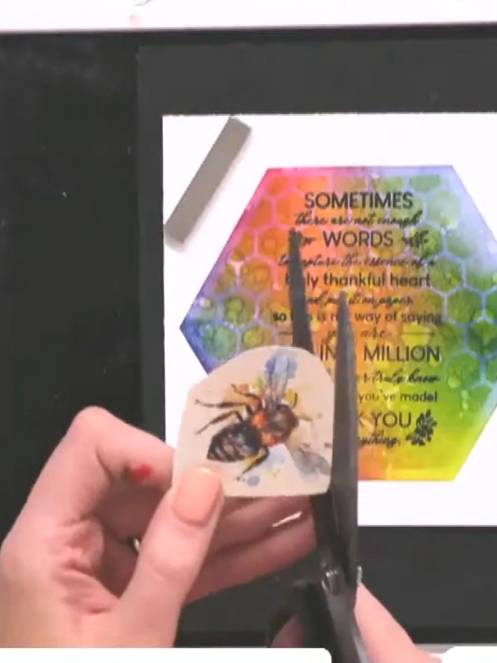 Step 1: Select a bee design from the Sweet Like Honey paper collection. Use scissors to carefully fussy-cut around the