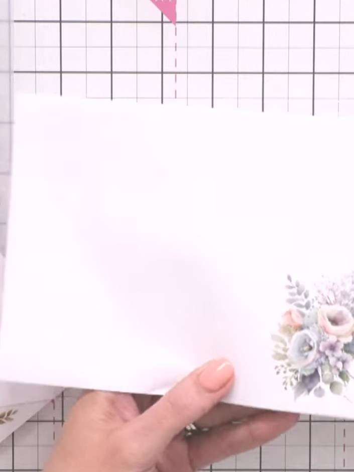 Step 6: Zieh die Trägerfolie vorsichtig vom Umschlag ab, um das übertragene Blumenmotiv freizulegen.