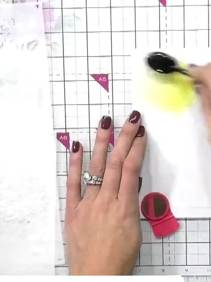 Step 2: Using stencil number one, apply yellow ink through the stencil onto white card stock using a brush, focusing o