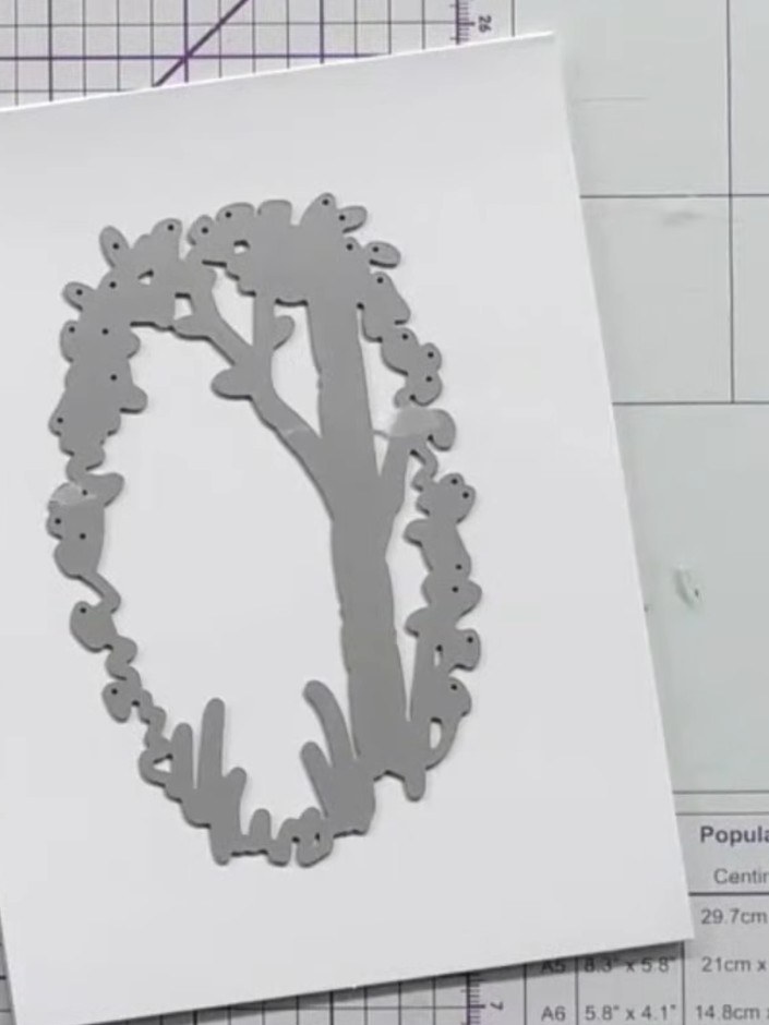 Step 2: Run the white card blank through your die-cutting machine with the floral wreath die to create the aperture wi