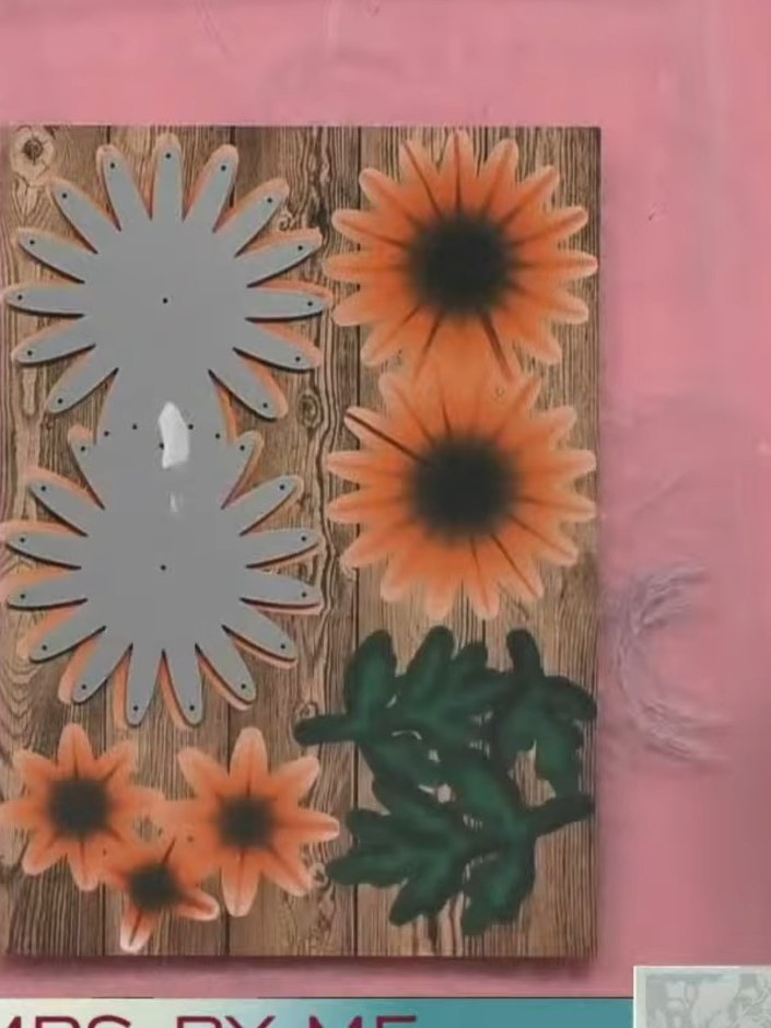Step 1: Position the grey die-cut flower shape onto the pre-printed wood-effect card with orange chrysanthemum flowers