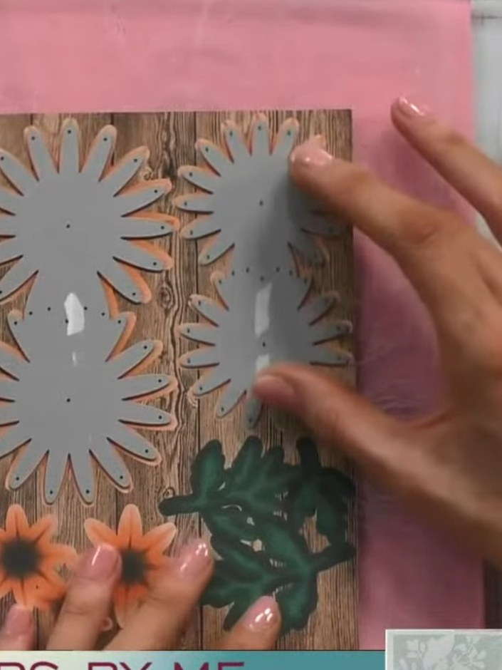 Step 2: Position the die-cut chrysanthemum pieces on the wood-effect card base. If the die doesn't align properly, fli