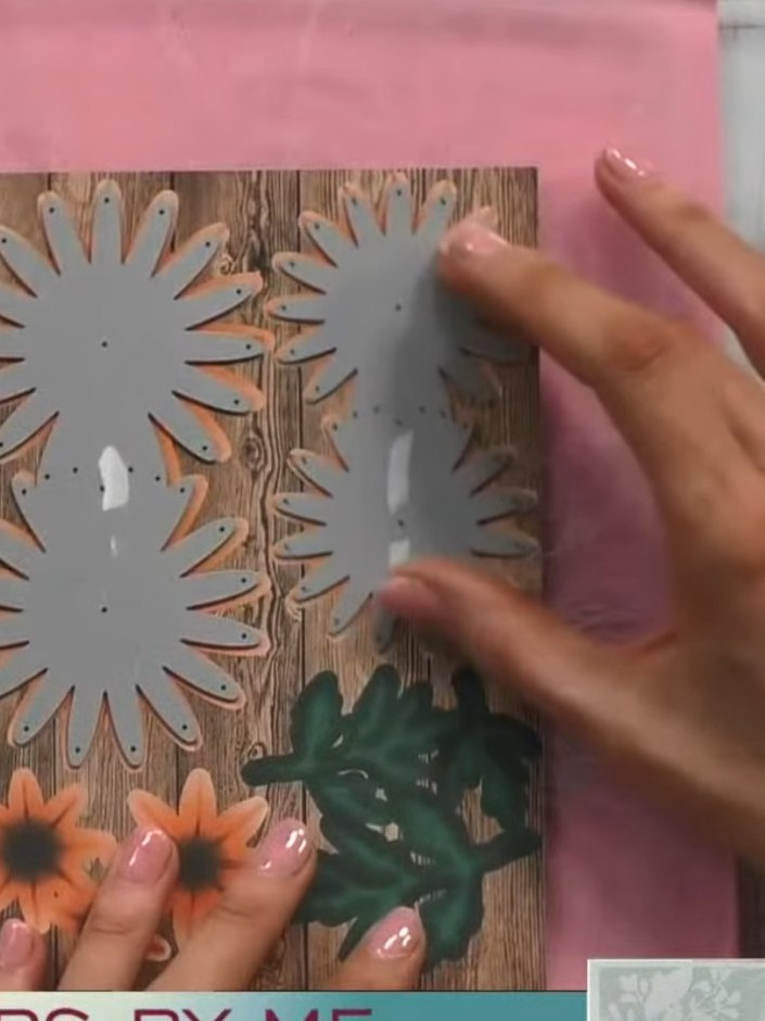 Step 3: Lass Stanzschablone und Cardstock durch deine Stanzmaschine laufen. The grey die-cut flower shapes will be released f