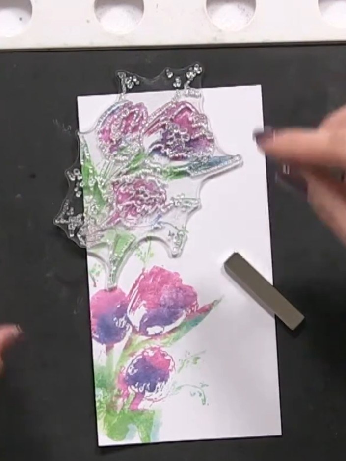 Step 10: Ink the outline stamp in black and press it onto the card to define the floral design. Ensure the stamp aligns