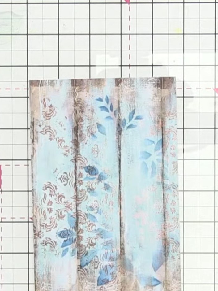 Step 5: Carefully remove the stencil to reveal the dimensional teal ink pattern on the leaves. Observe the textured ef