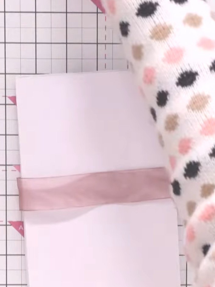 Step 16: Binde das Band zu einer Schleife um das Album und kürze die Enden auf die Länge, die dir gefällt.