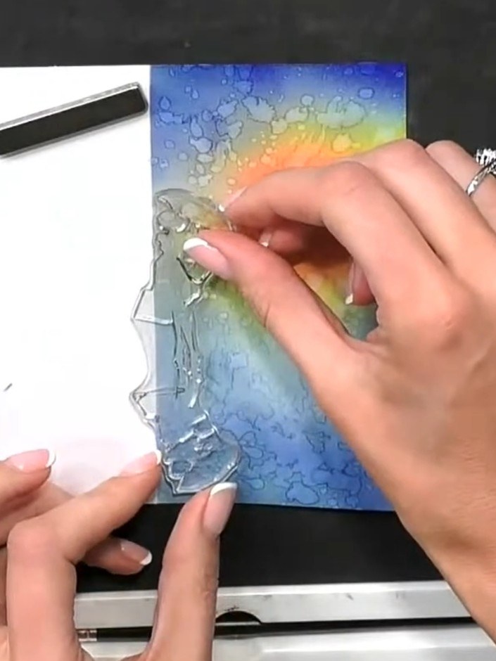 Step 11: Stamp the silhouette figure with its reflection onto the dried ink-blended background using black ink. Positio