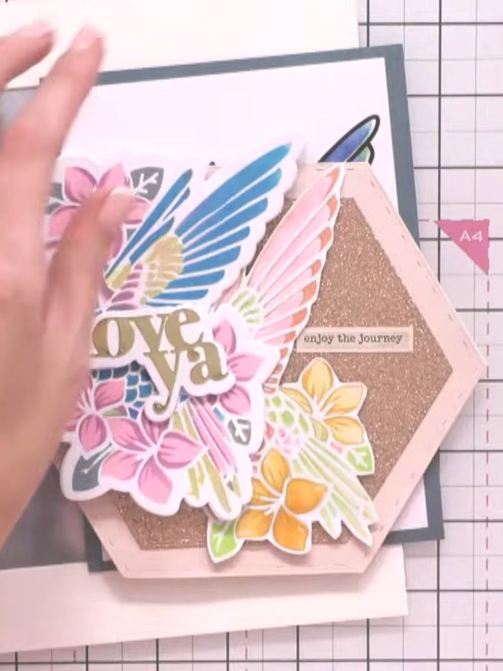 Step 8: Mount your finished floral design onto the pink hexagonal card base. Position the decorated panel centrally an
