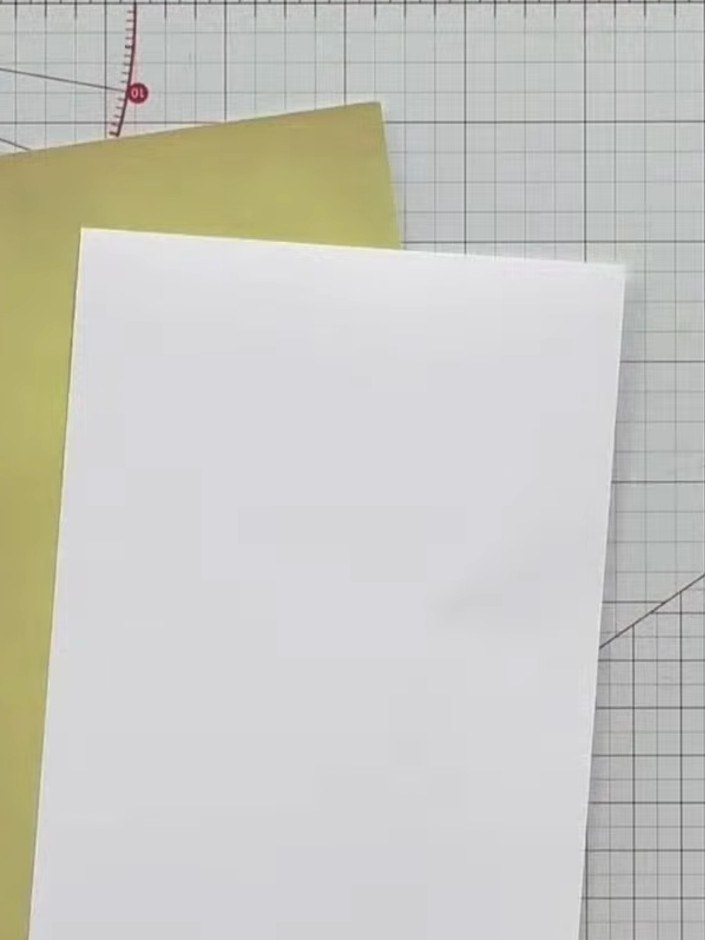 Step 2: Select a white card blank as your base. Layer a piece of yellow pattern paper and a white panel on top to crea