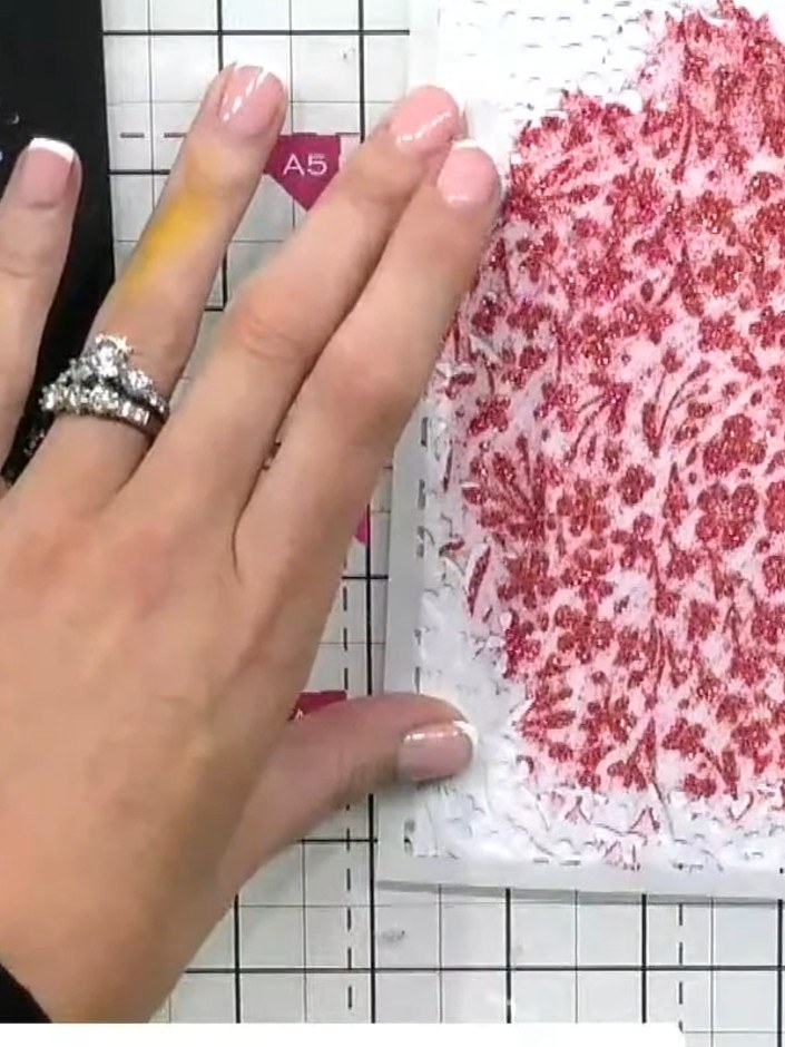 Step 5: Carefully lift away the stencil to reveal the ditsy floral design in pink paste on your white card.