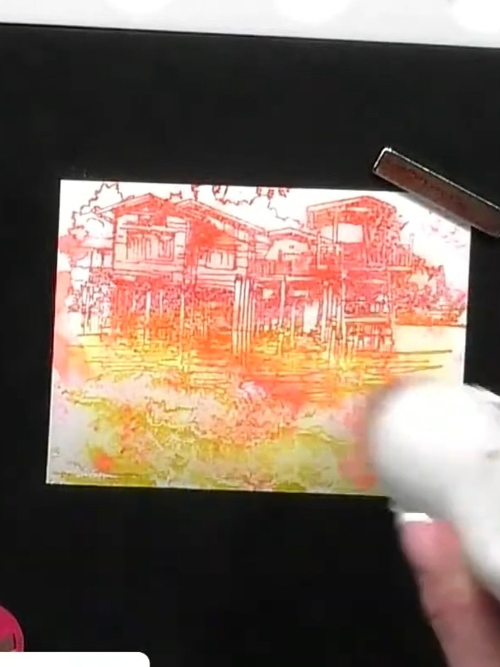 Step 4: Hold the Scenery Escape stamp over the watercolour base. Ink the stamp with orange at the top, pink in the mid