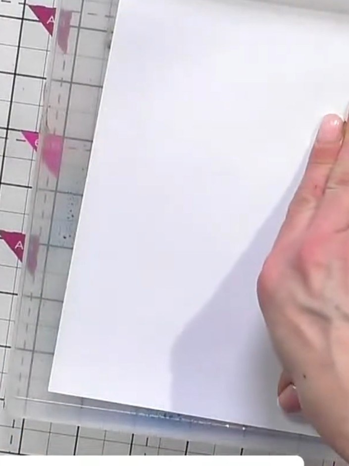Step 4: Press white card stock firmly onto the inked gel plate to transfer the mandala design. Use your hand to smooth