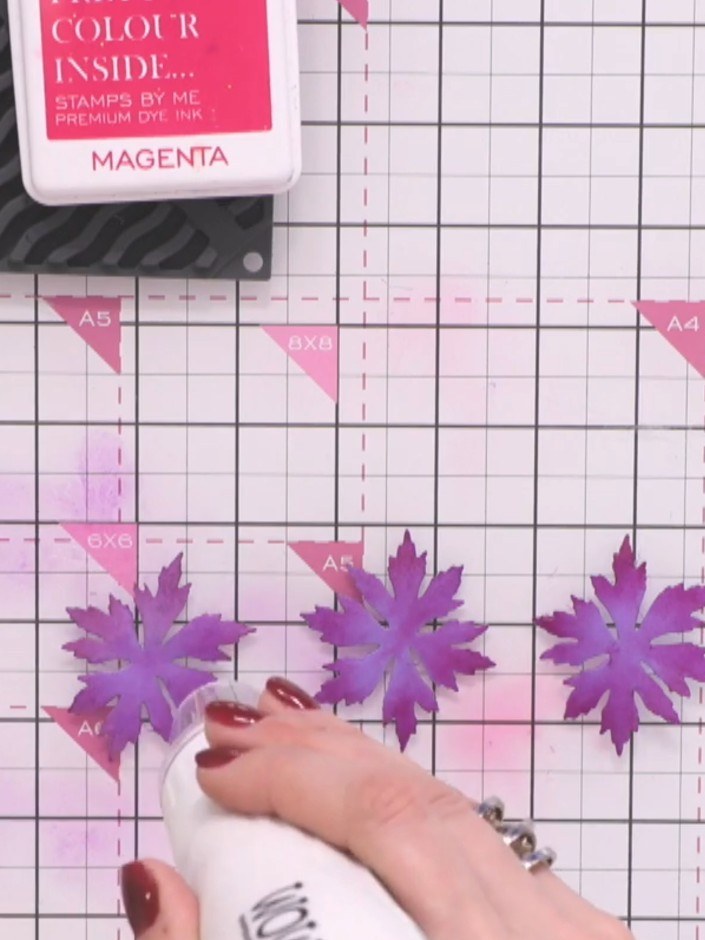 Step 7: Spray one set of purple flowers lightly with water using a spray bottle. Gently scrunch the dampened flowers t