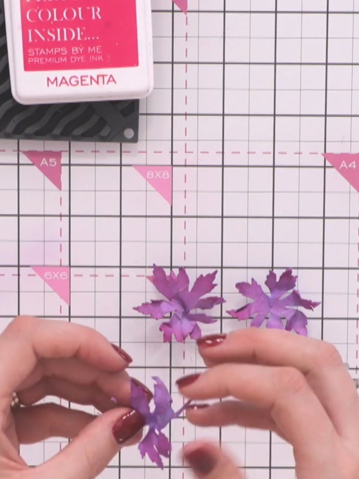 Step 8: Carefully unravel and straighten the scrunched purple flowers. Add additional magenta ink to the creases and e