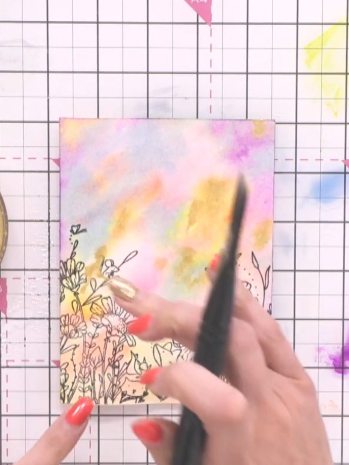 Step 7: Use your finger to push the gold paint around and blend it into the watercolour background. Tidy up any puddle