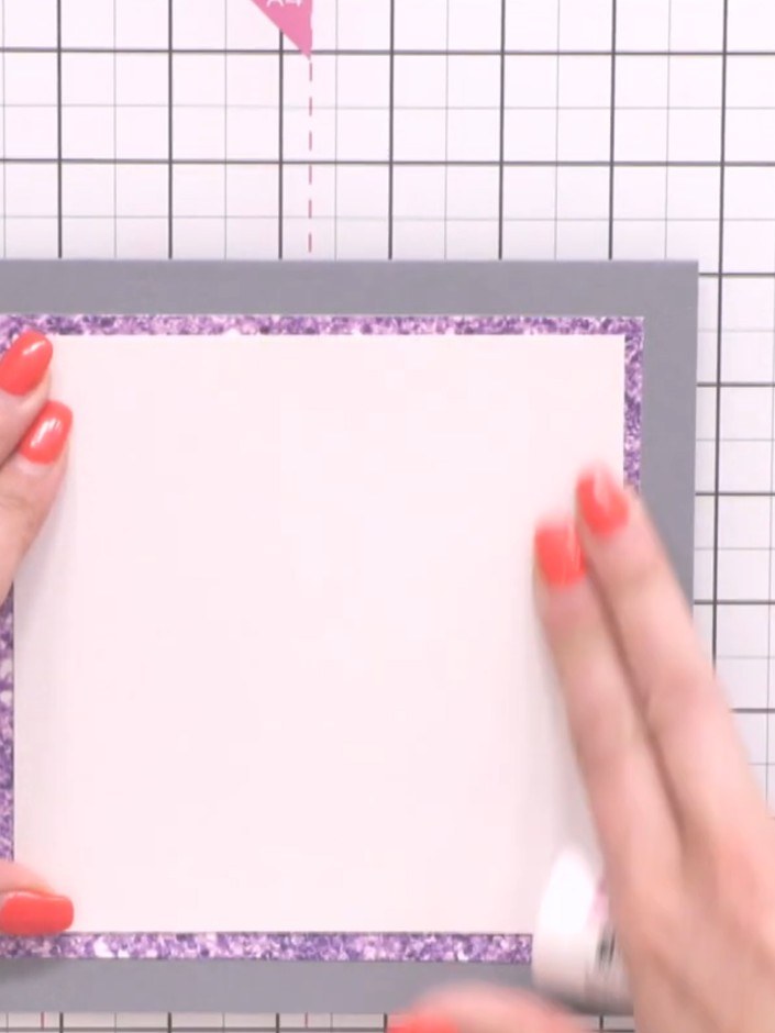 Step 4: Klebe das glitzernde lila Papier auf die graue quadratische Kartenbasis – so entsteht ein dekorativer Rahmen.