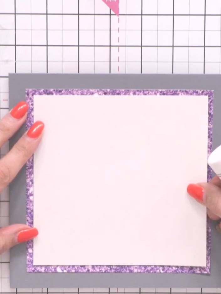 Step 5: Adhere a piece of white cardstock on top of the purple glitter border to create contrast and break up the desi